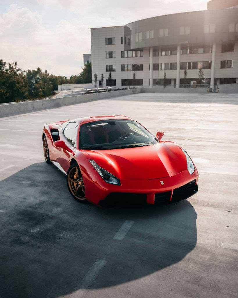 red Ferrari 488 Spider sports car in a car park